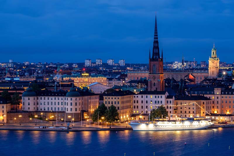 Kvällsutsikt över Gamla stan och Riddarholmen med upplysta byggnader och vatten